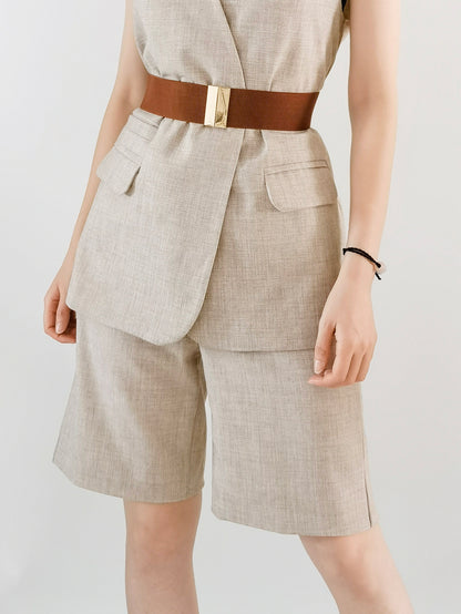 Person wearing a beige suit with a brown belt on a plain background