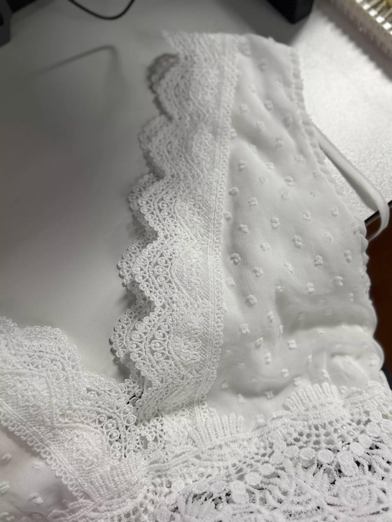 White lace garment on a mannequin with a blurred background