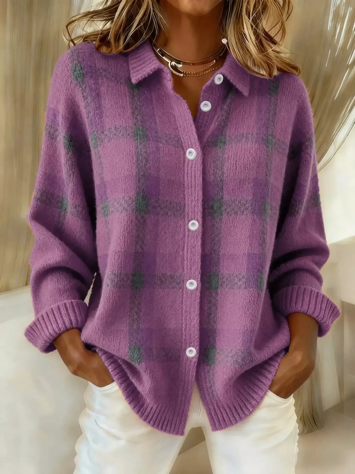 Person wearing a purple plaid cardigan with a neutral background