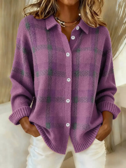 Person wearing a purple plaid cardigan with a neutral background