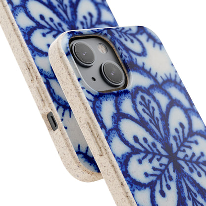 A close-up of a smartphone case with a blue floral mandala pattern on a white background and a textured beige bumper edge, shown on a phone against a white studio background.