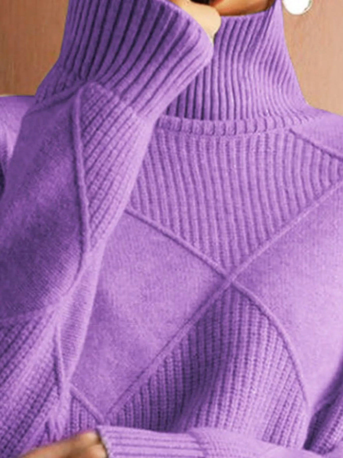 Close-up of a person wearing a purple ribbed turtleneck sweater, showing the knit texture and collar detail.