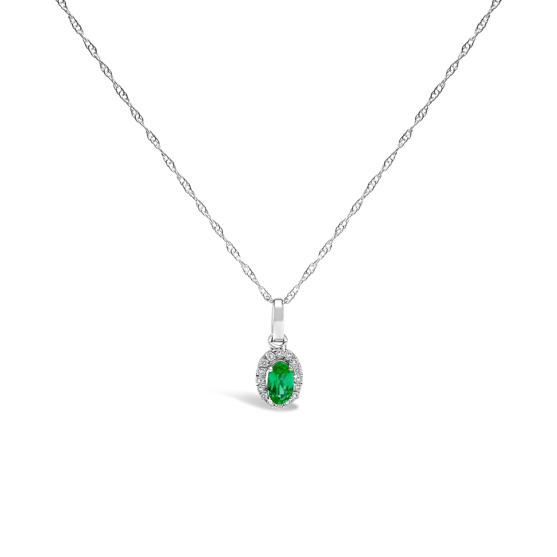 10K white gold pendant necklace featuring a 5x3mm green emerald surrounded by diamond accents on an 18" chain.