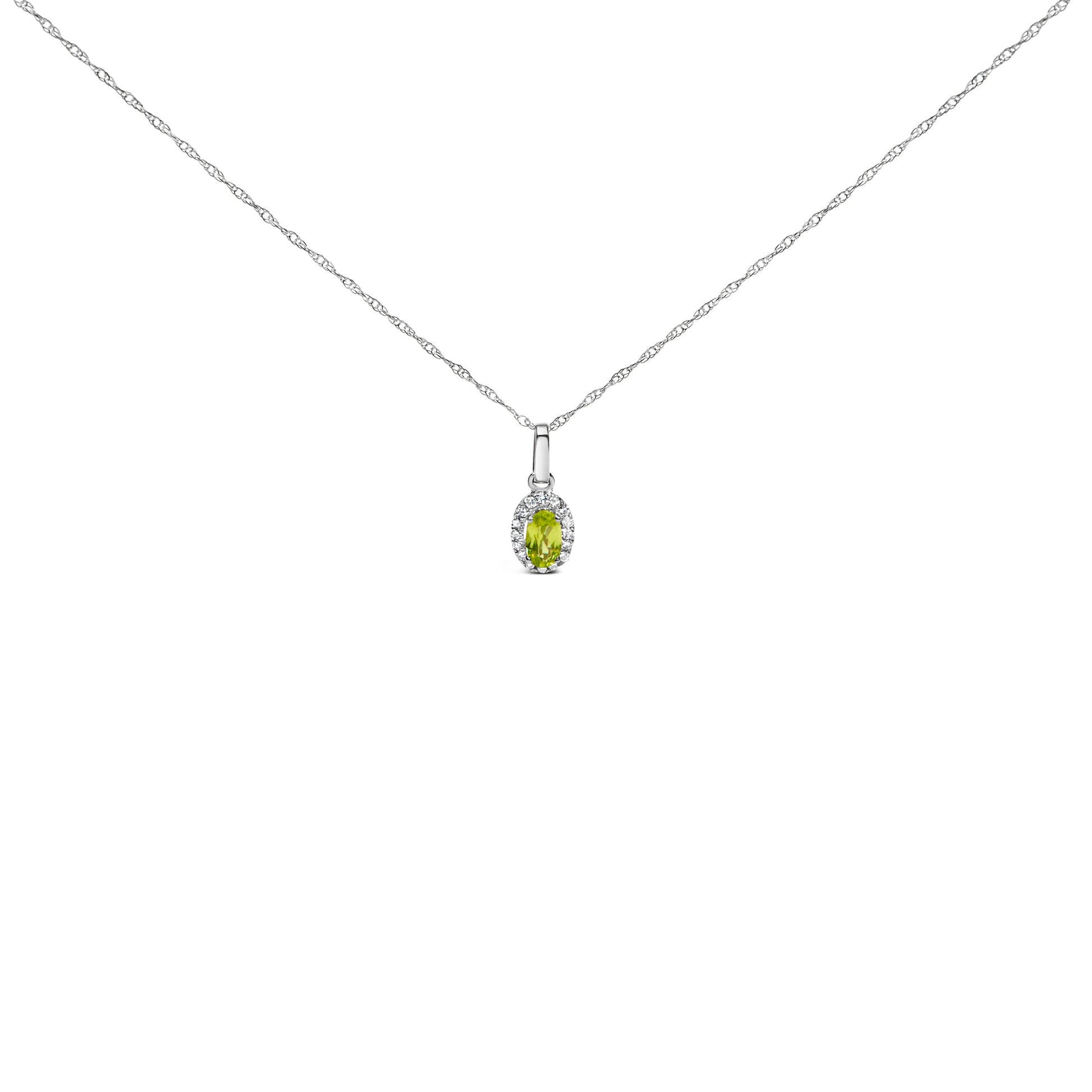 10K white gold pendant necklace featuring a 5x3mm green emerald surrounded by diamond accents in an oval shape.