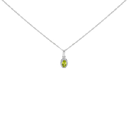 10K white gold pendant necklace featuring a 5x3mm green emerald surrounded by diamond accents in an oval shape.