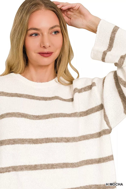 A woman wearing a fuzzy knit sweater with horizontal taupe-brown stripes on an off-white base, shown against a plain white background.