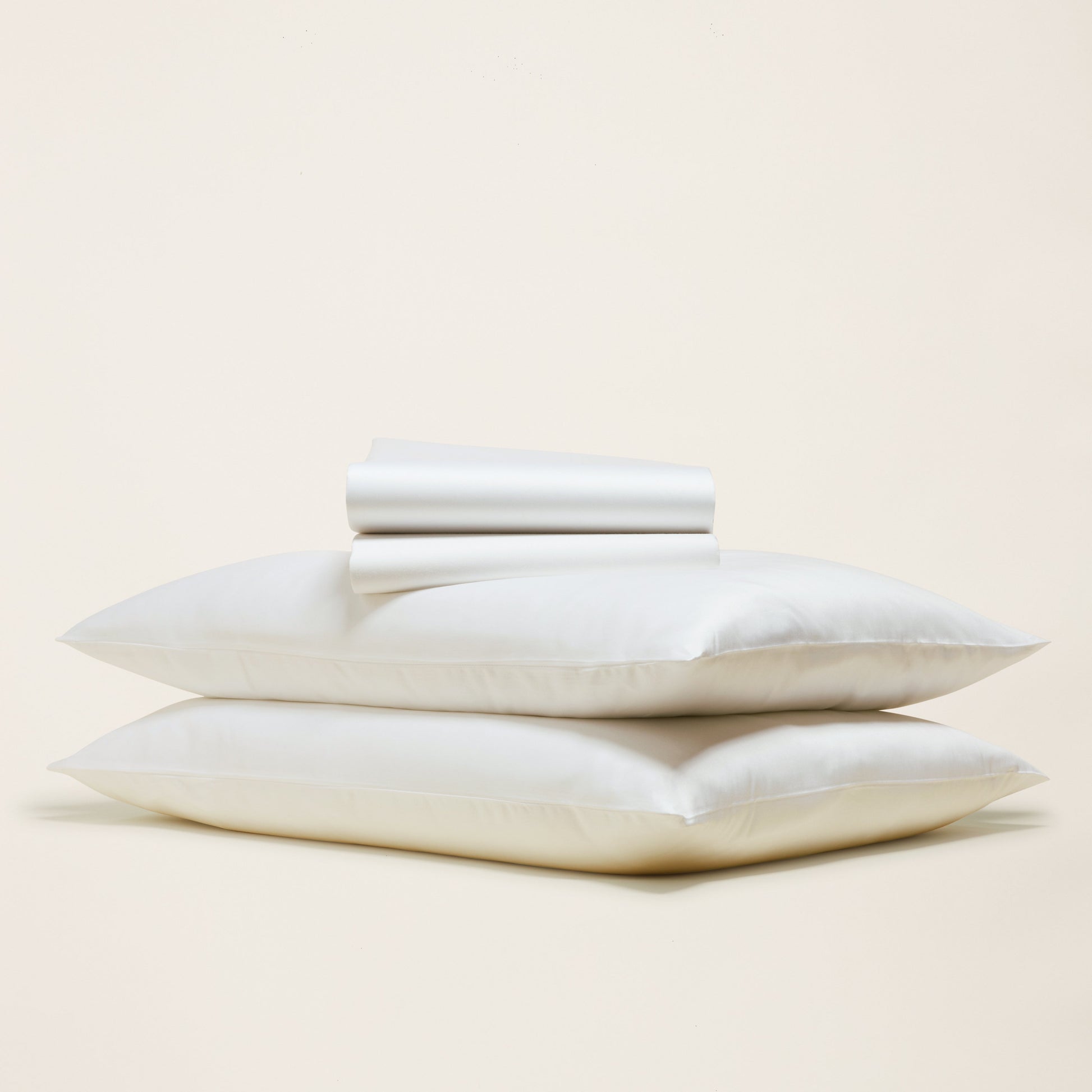 Stack of white pillows on a beige background