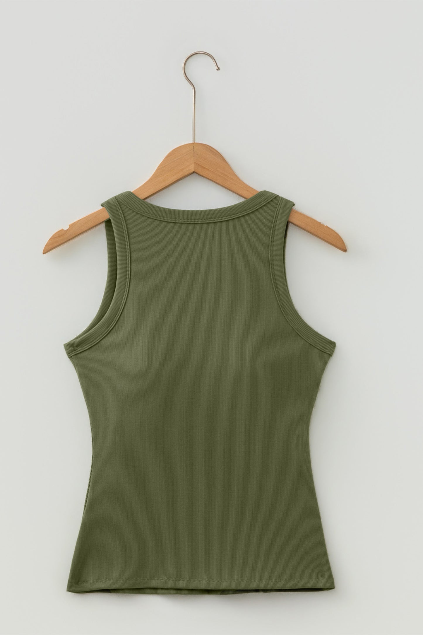 Green tank top on a wooden hanger against a white background