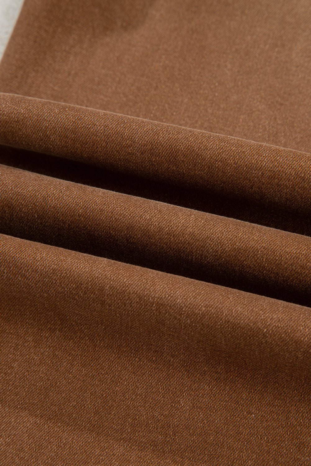 Close up view of brown wide leg cropped jeans.