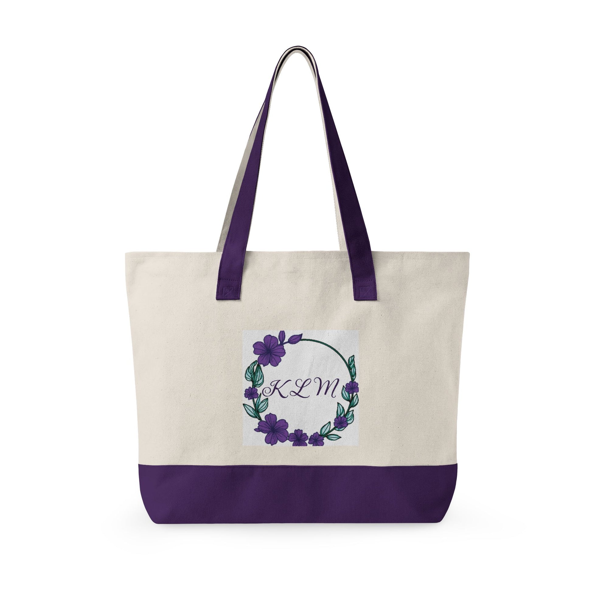 Cream canvas tote bag with purple base and straps, featuring a purple floral wreath and the monogram KLM.