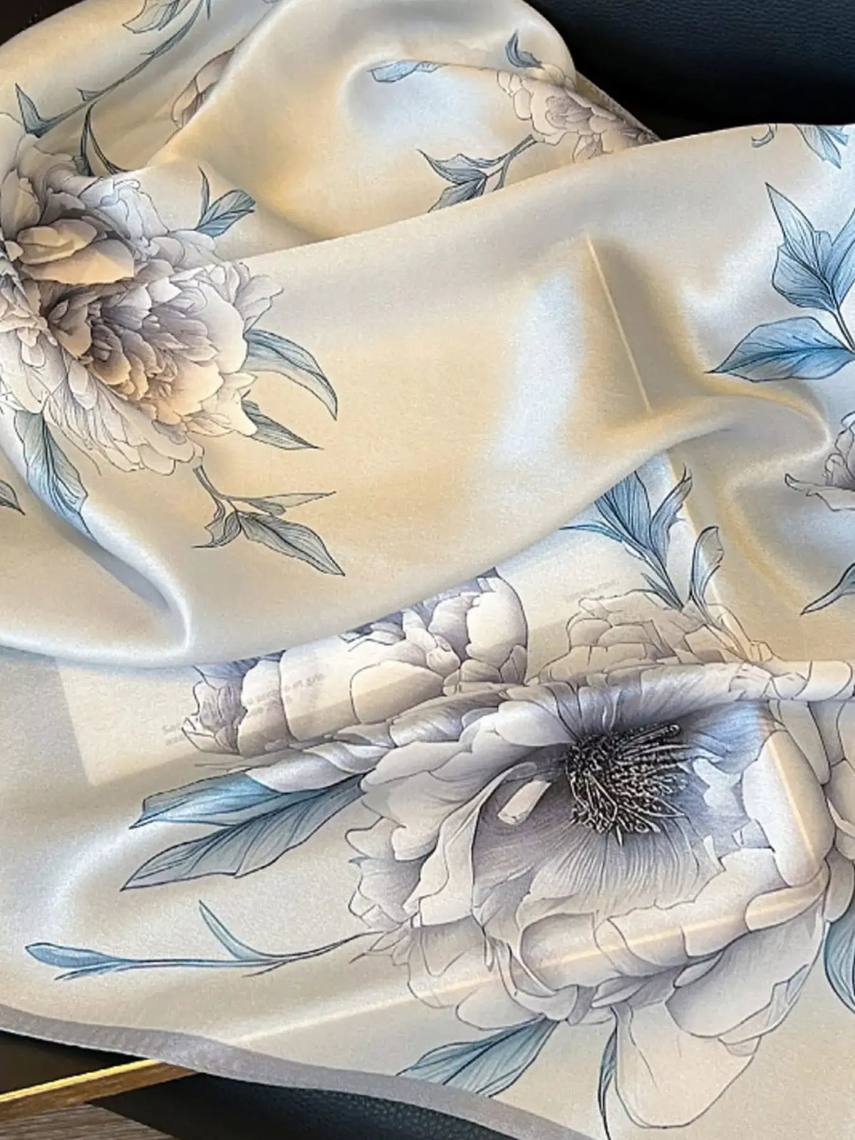 Close-up of the floral print pattern on a premium silk square scarf