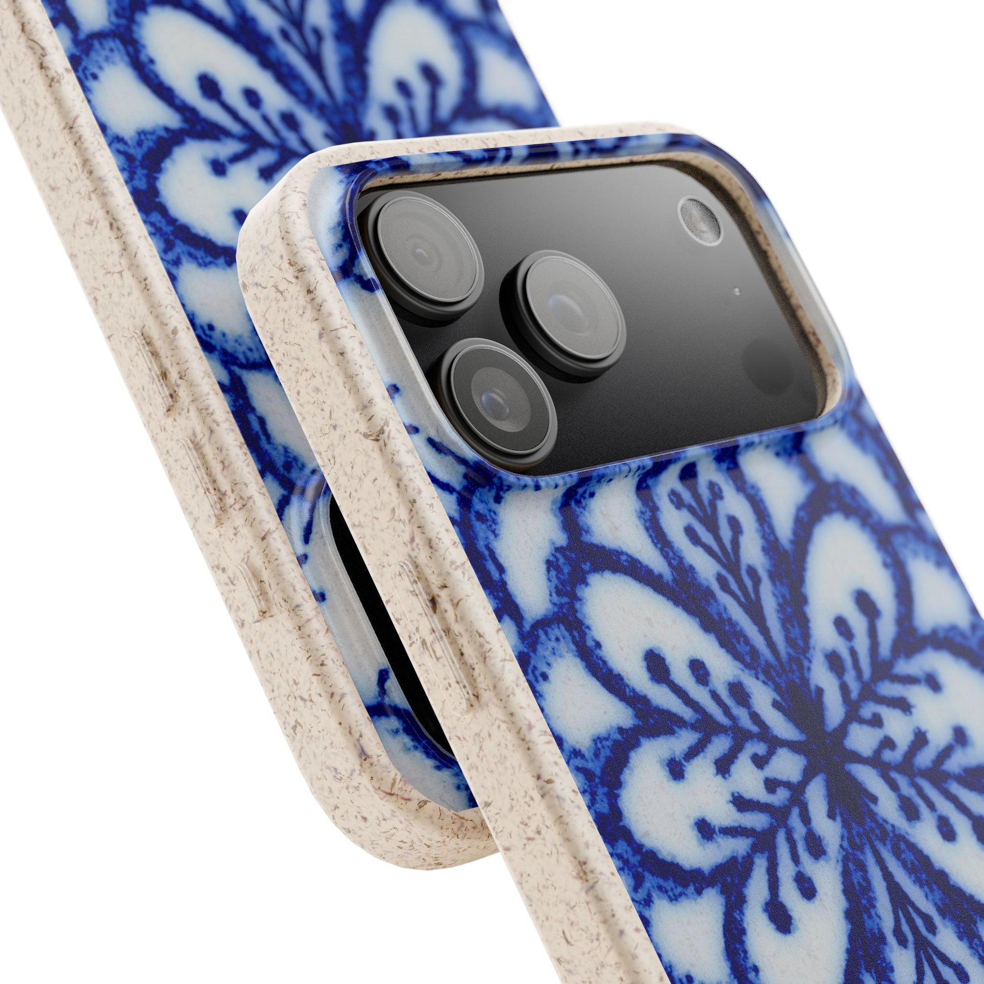 A close-up of a smartphone case with a blue and white floral pattern and a textured beige side bumper, shown fitted on a phone against a white background.
