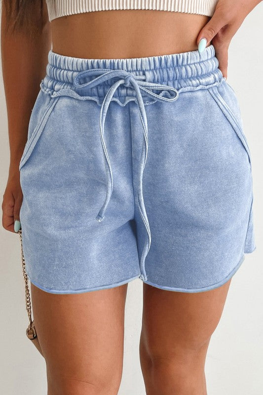 Light blue shorts with drawstring waist on a plain background