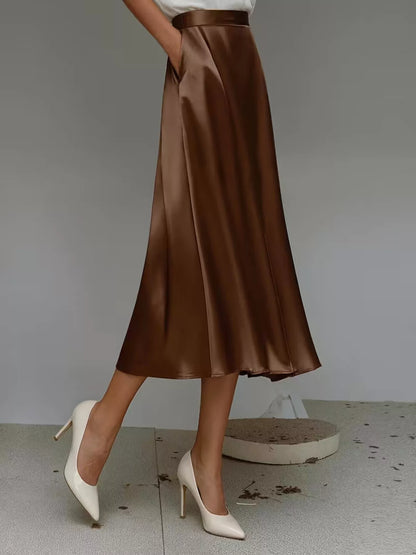 Brown satin skirt worn by a person on a plain background