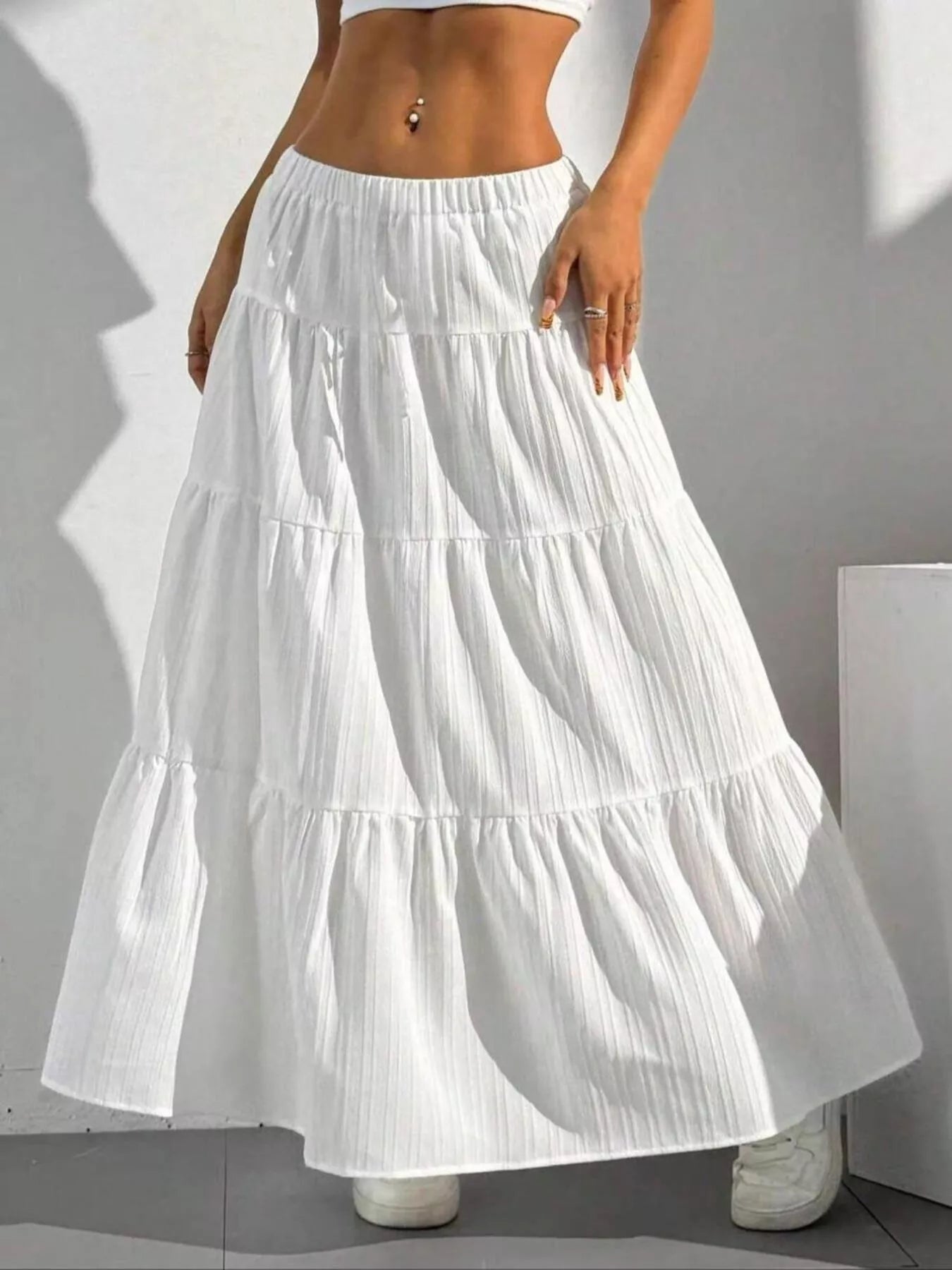 White tiered skirt worn by a person on a gray background