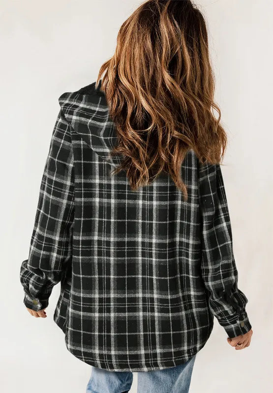 Person wearing a black and white plaid shirt with a hood on a plain background