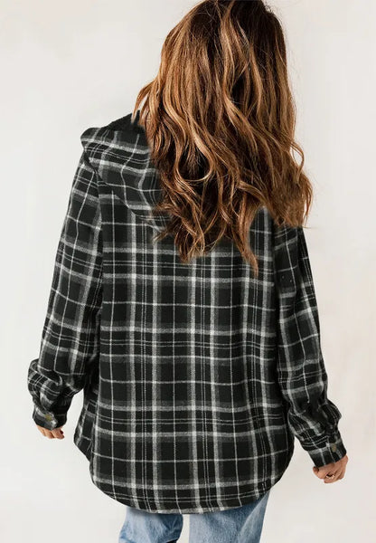 Person wearing a black and white plaid shirt with a hood on a plain background