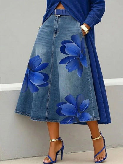 Denim skirt with blue floral patterns worn by a person against a neutral background