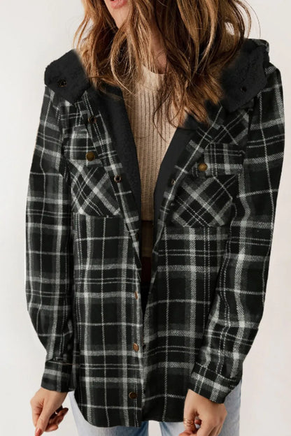 Person wearing a black and gray plaid coat on a white background