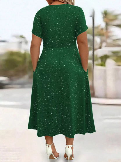 Green dress with white speckles worn by a person, blurred outdoor background