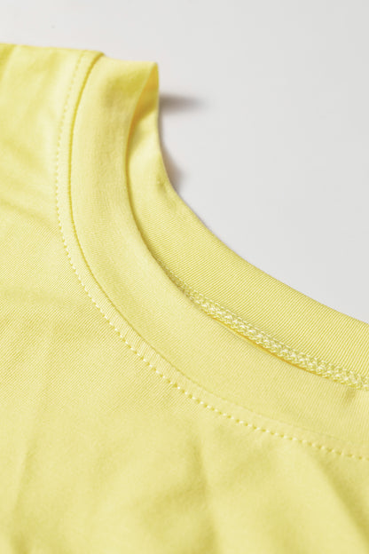 Close-up of a light yellow crew-neck t-shirt showing the ribbed collar and stitching details against a plain light gray background.