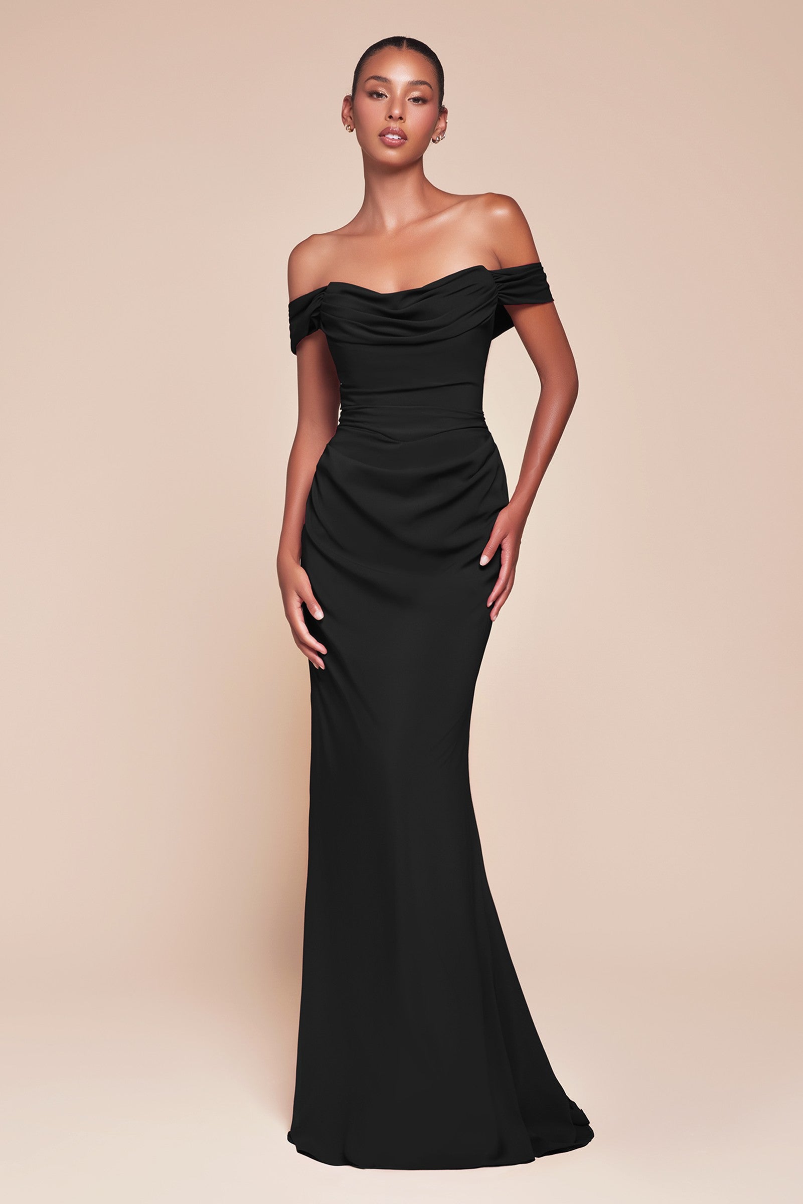 Woman wearing a black off-shoulder gown on a beige background