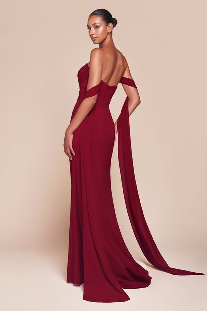 Woman wearing a burgundy evening gown with cut-out design on a beige background