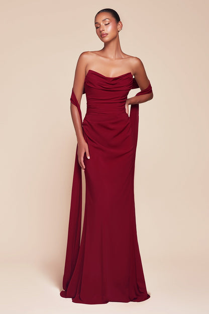 Woman wearing a burgundy strapless gown against a beige background