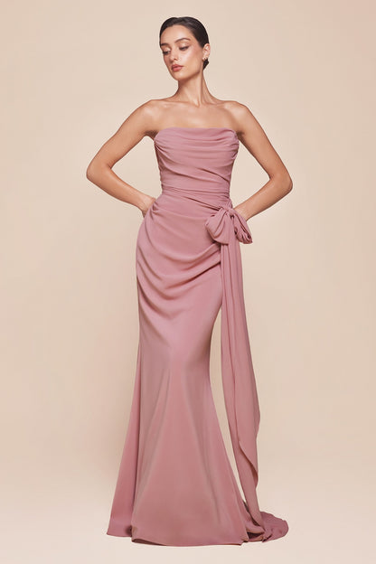 Woman wearing a strapless, flowing pink gown against a beige background