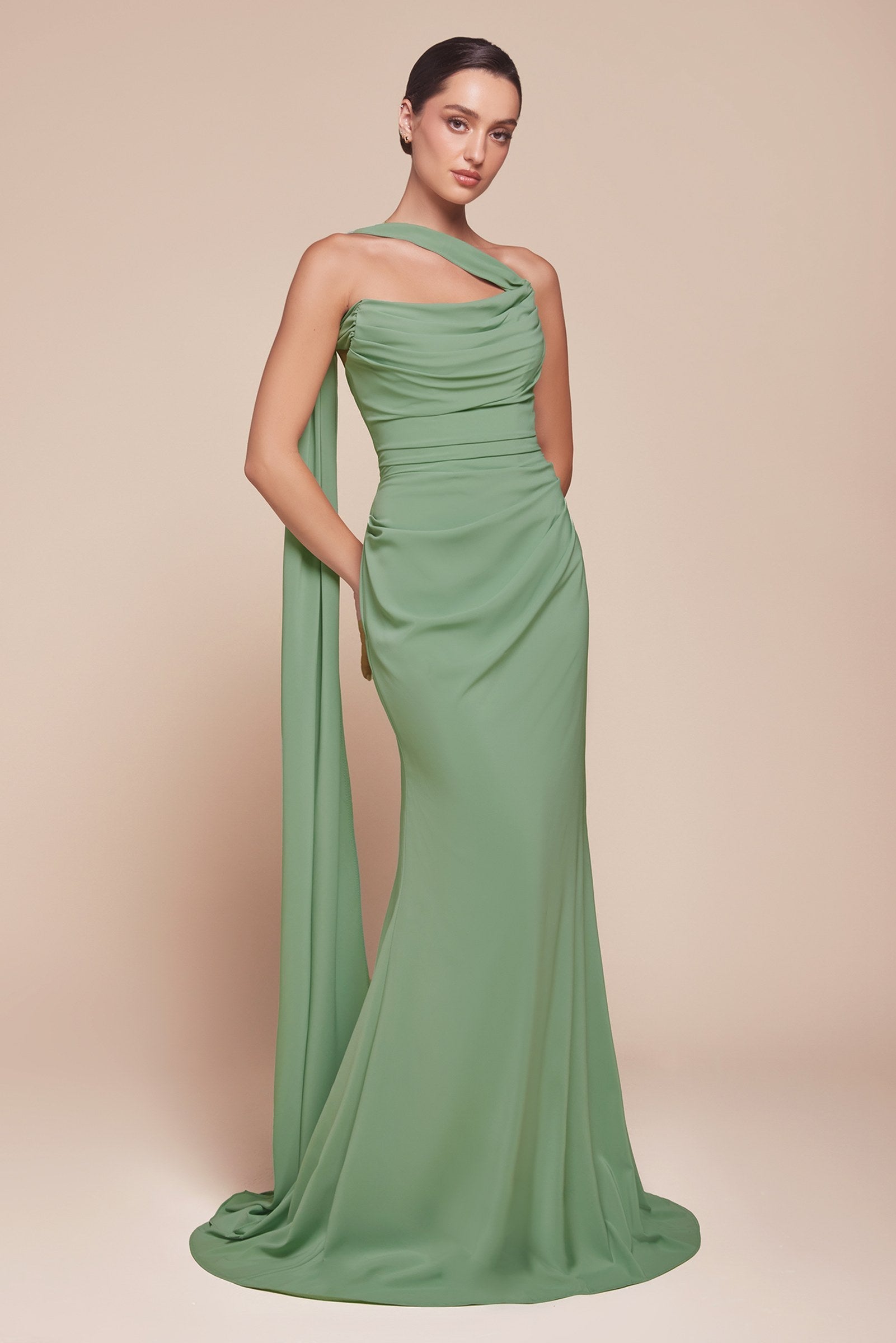 Woman wearing a green one-shoulder gown against a beige background