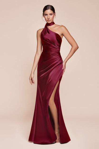 Woman wearing a burgundy halter neck gown with a slit on a beige background