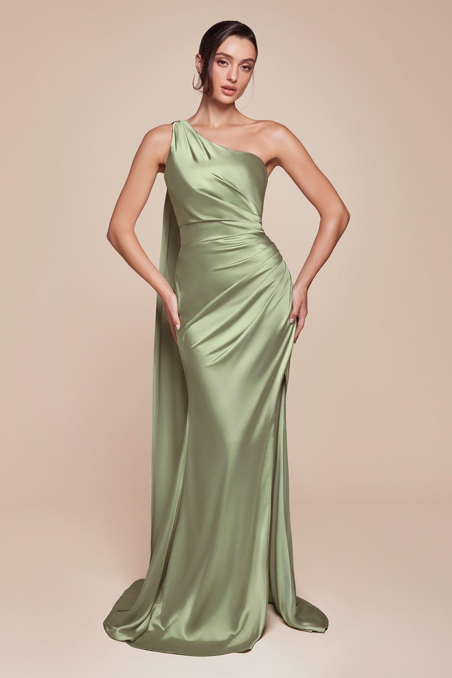 Woman wearing a green one-shoulder evening gown on a beige background