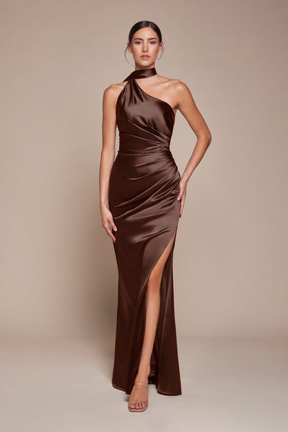Woman wearing a brown halter neck gown with a slit on a beige background