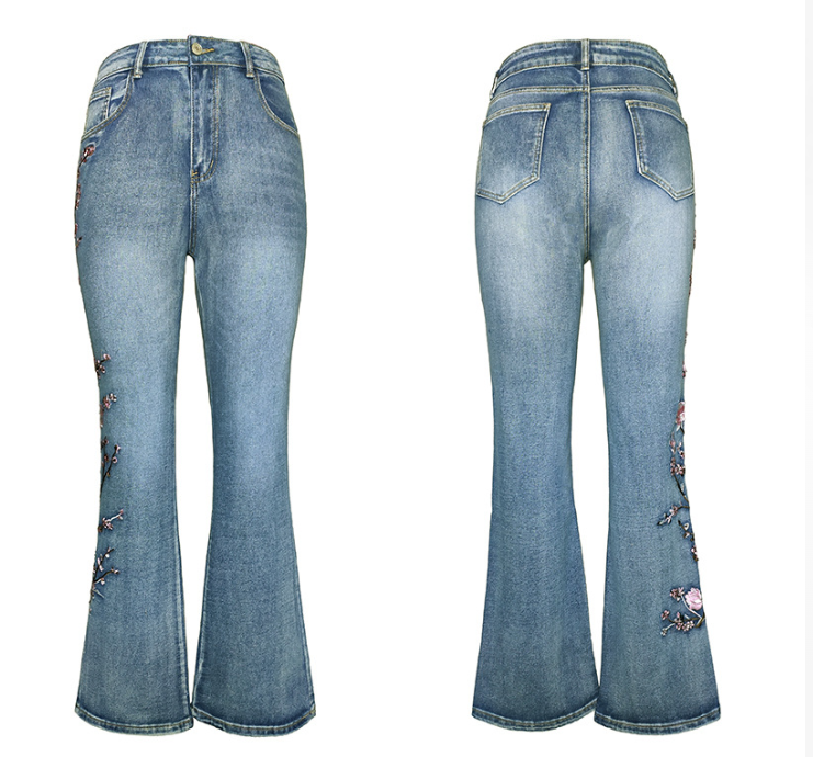 Front and back views of light blue denim flare jeans with floral embroidery on the lower legs, shown on a plain white background.