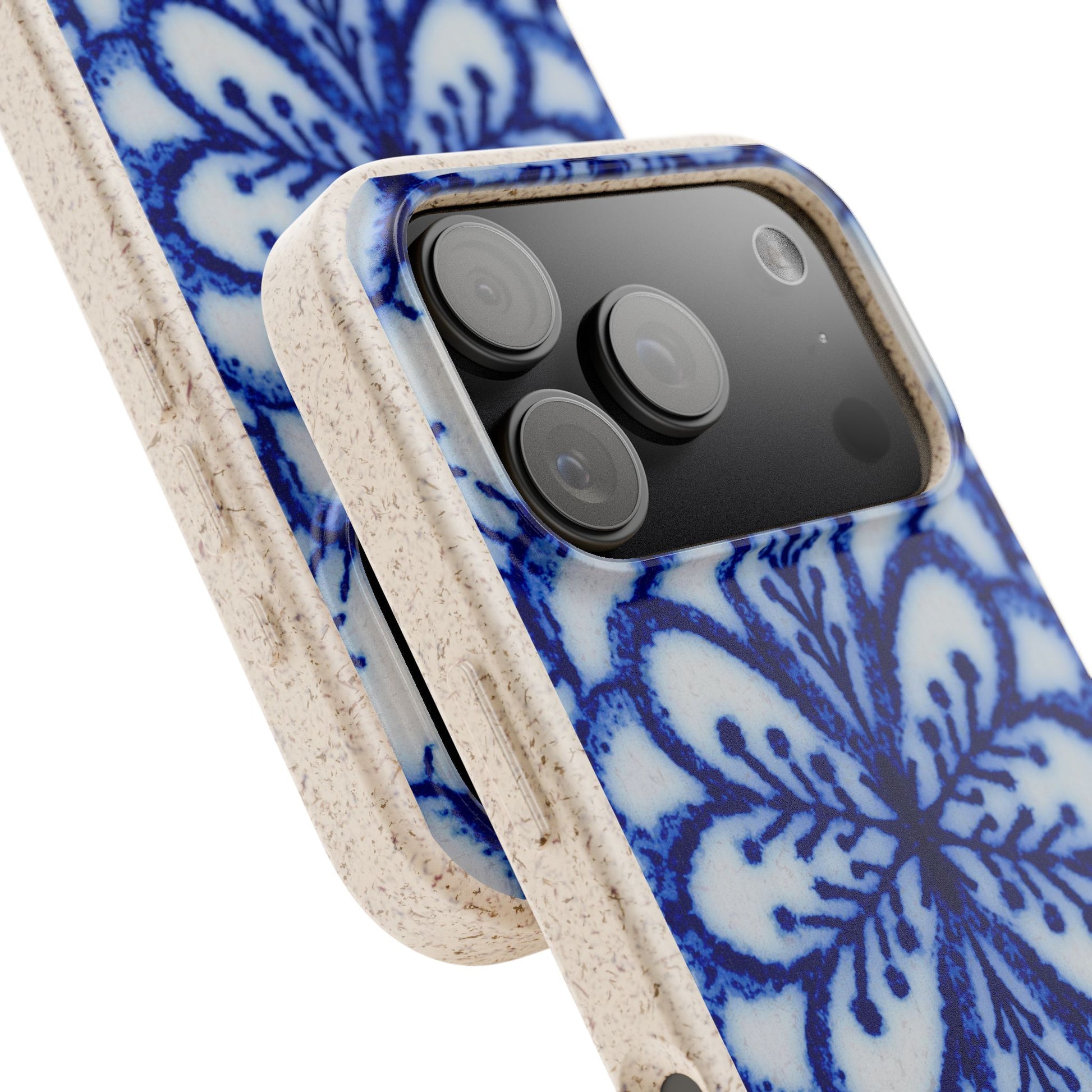 A close-up of a smartphone case with a blue floral pattern on a white base and a natural beige textured side bumper, shown fitted on a phone against a white background.