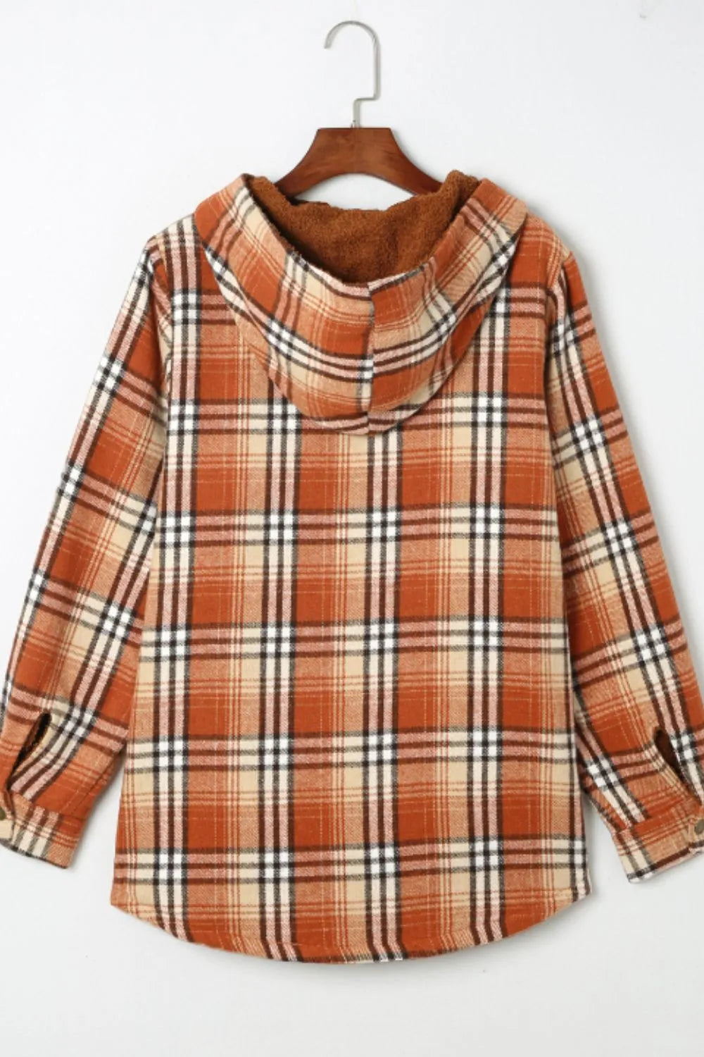 Plaid shirt with brown and white pattern on a hanger against a white background
