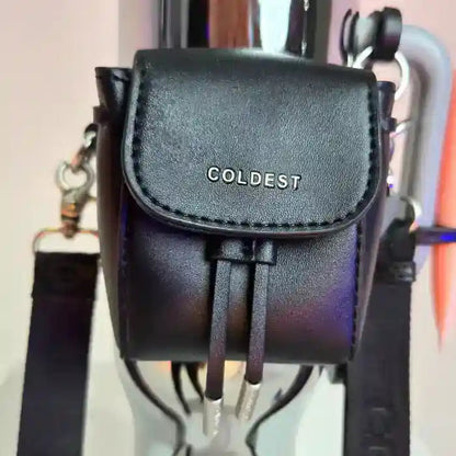 Black mini backpack with a clasp, featuring the word "COLDEST" embossed on the front, attached to a water bottle.