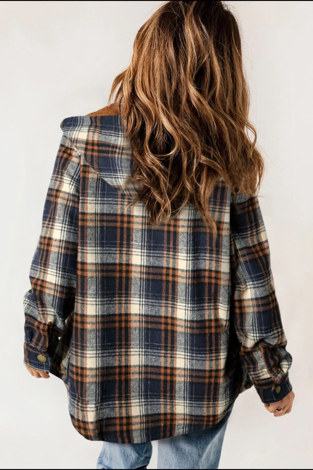 Person wearing a plaid shirt with a plain background