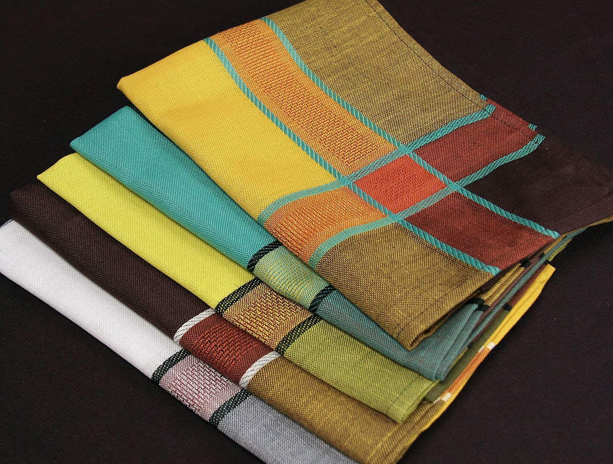 A stack of folded woven fabric handkerchiefs or napkins in multiple colors, including yellow, teal, brown, white, and orange, with striped and plaid patterns, set against a dark background.