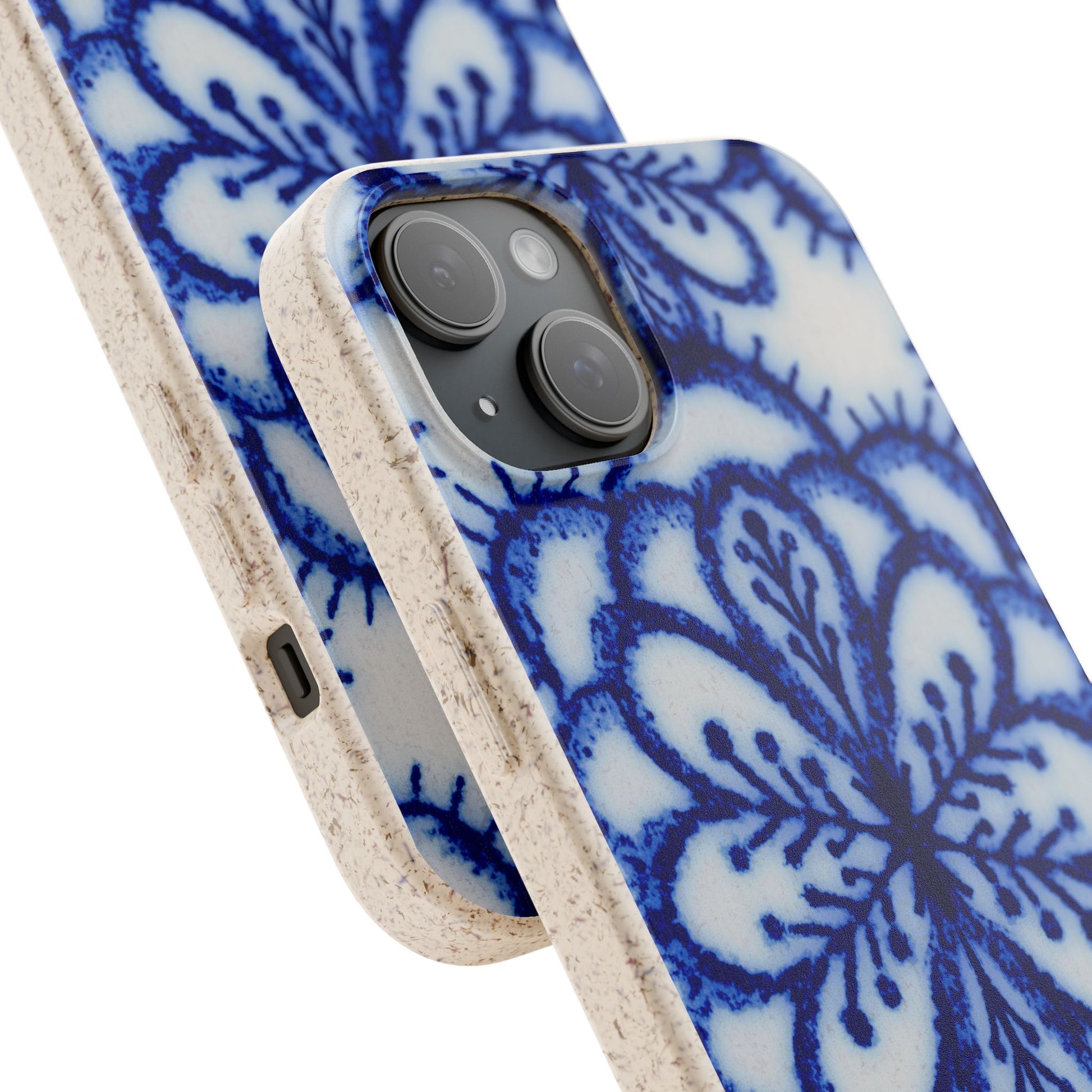 A close-up of a smartphone case with a blue floral mandala pattern on a white background and a natural beige textured border, shown on a phone against a white background.