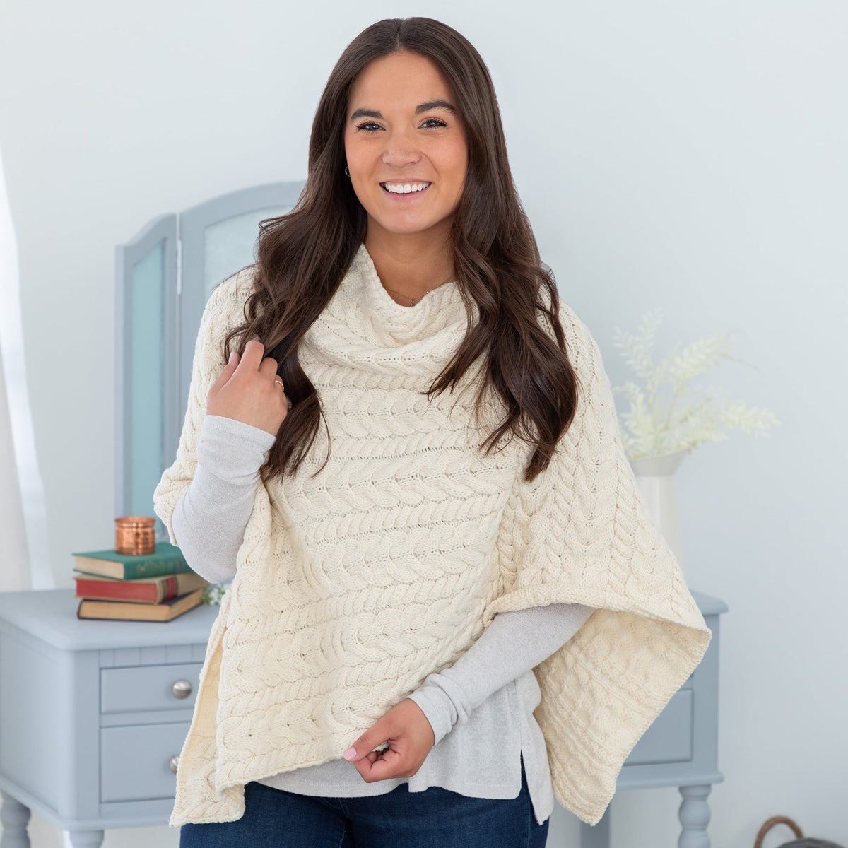 Woman wearing a cable knit wool poncho