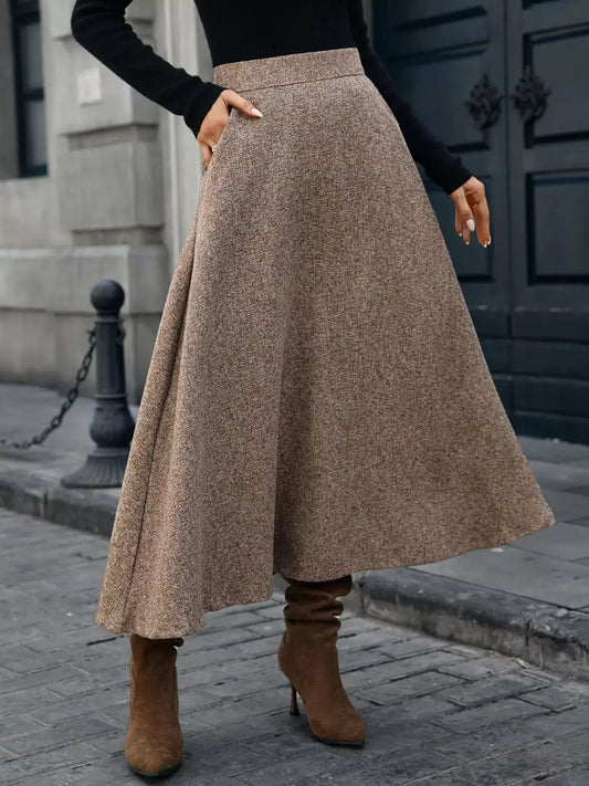 Person wearing a brown skirt and brown boots on a city street.