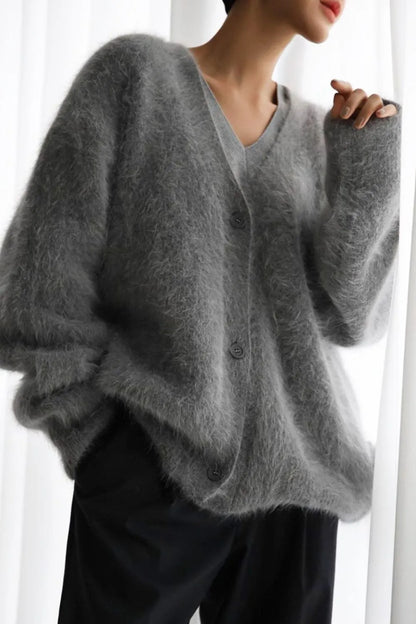 Person wearing a gray sweater with a blurred background