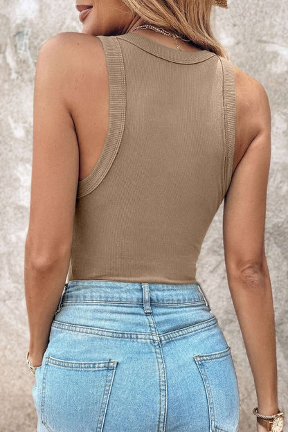 Rear view of a person wearing a tan ribbed fabric tank top tucked into light blue denim pants.