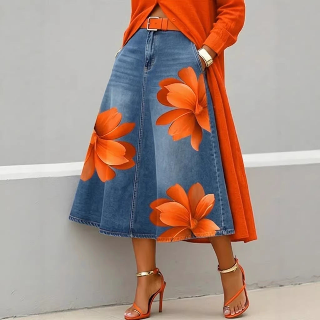 Person wearing an orange floral denim skirt with a matching top against a gray background