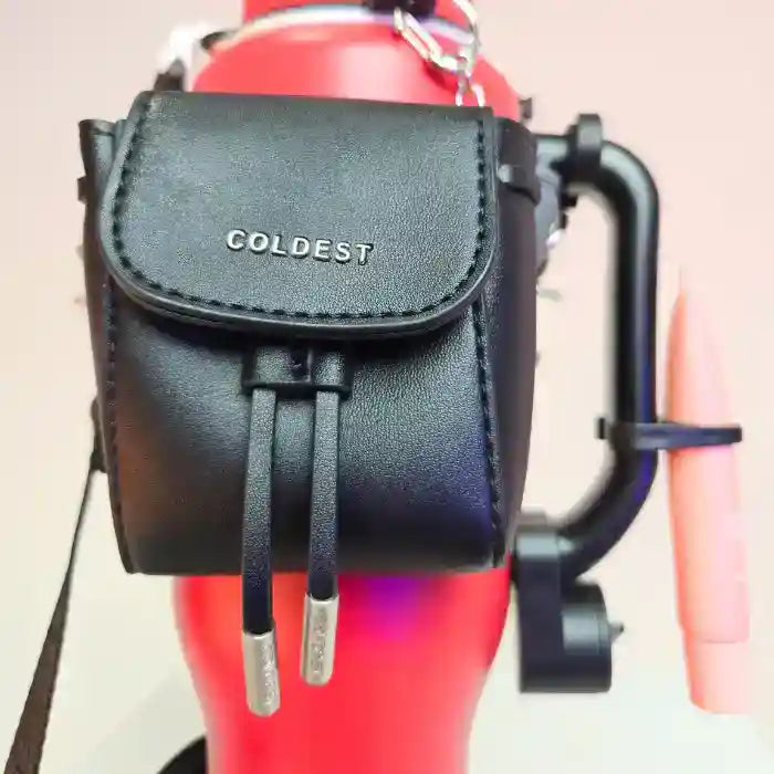 Red COLDEST water bottle with a black mini backpack holder, key hanger, and a pink squeeze pen attached.