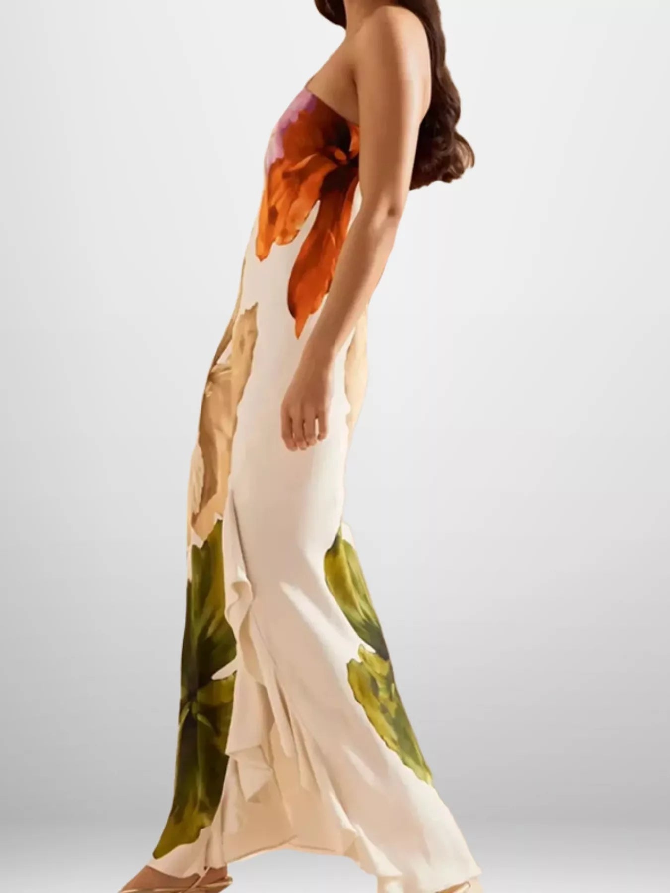 Woman wearing a long, floral-patterned dress on a plain background
