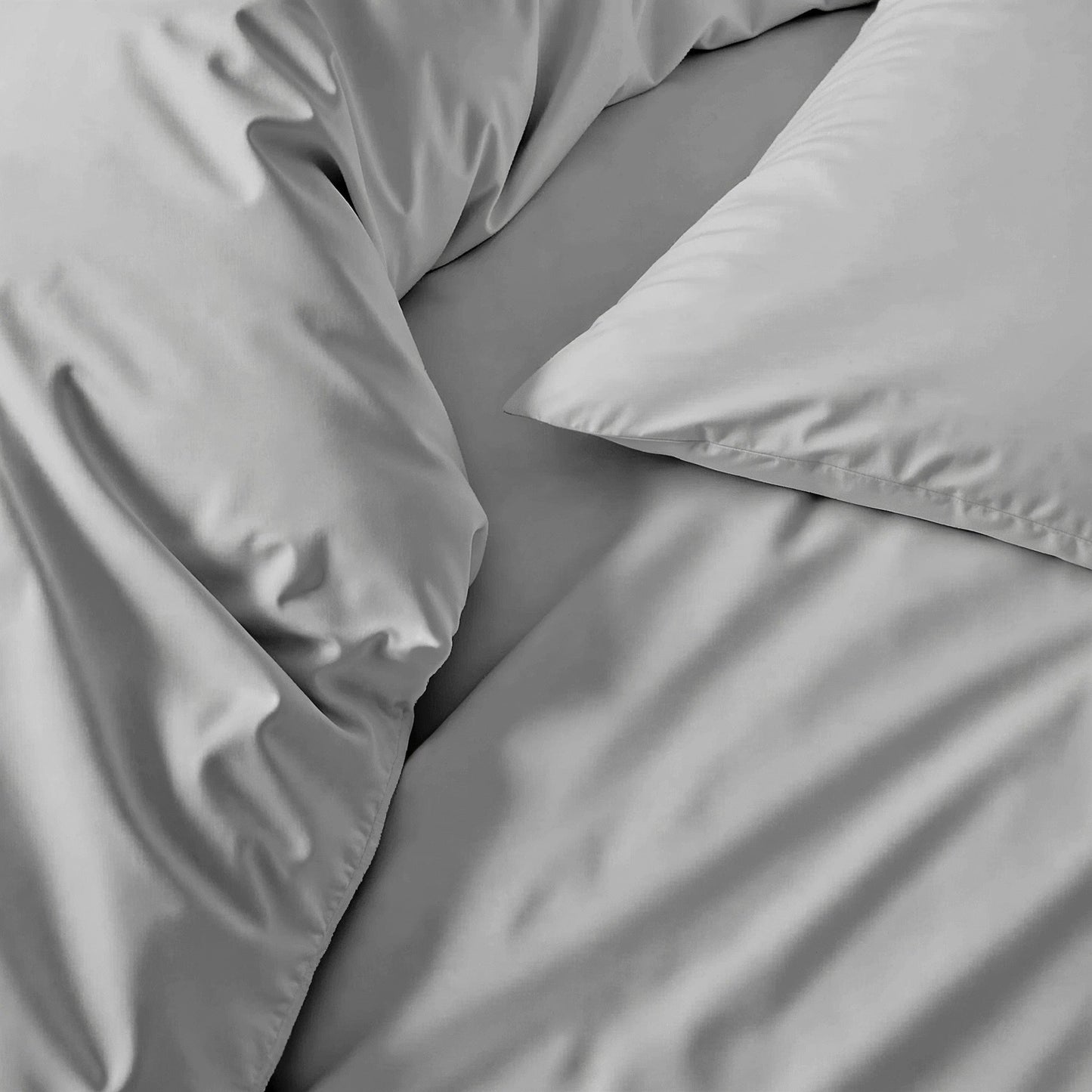 Gray bedding set with pillows on a bed