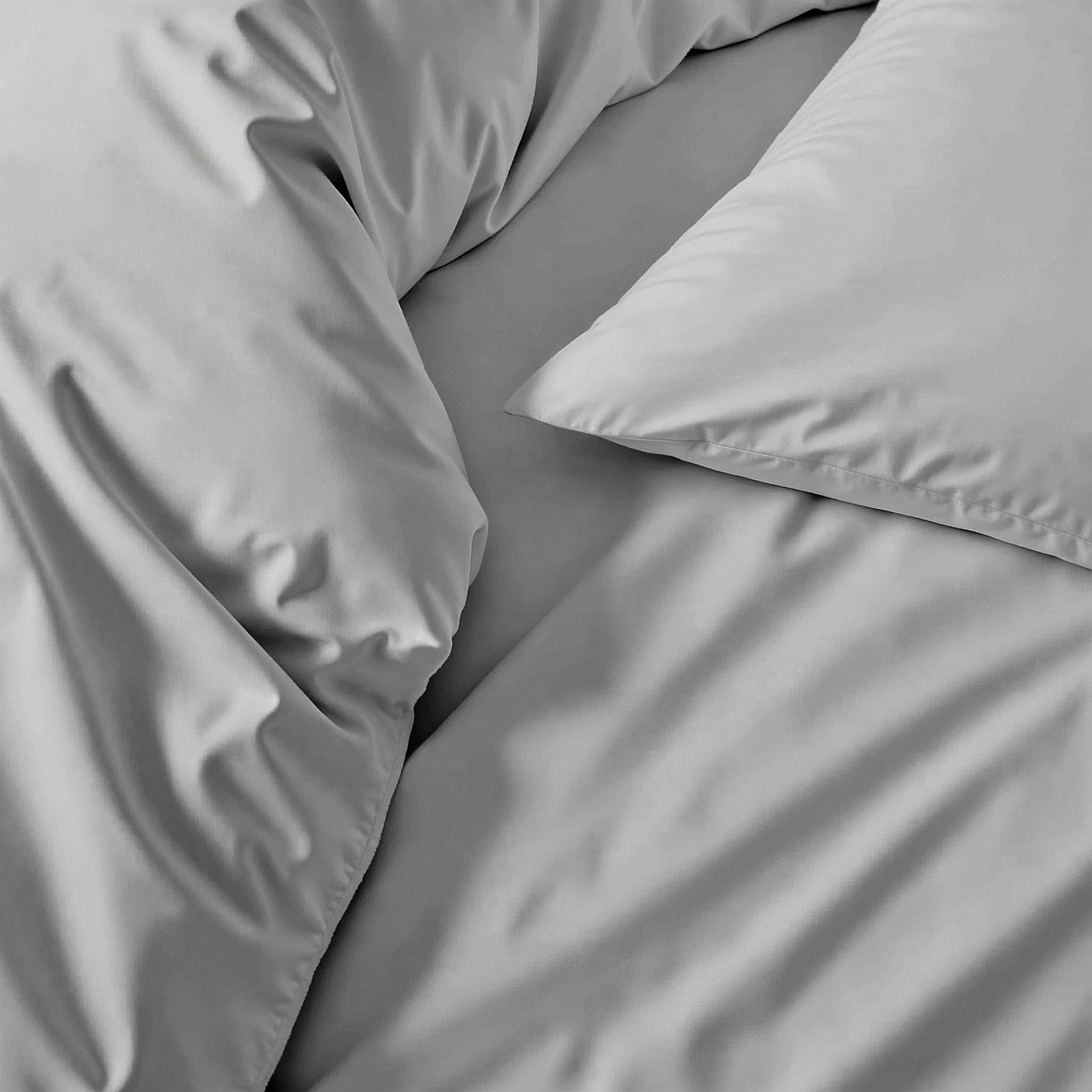 Gray bedding set with pillows on a bed