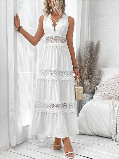 Woman wearing a white lace dress in a bright room with white walls and wooden floor.
